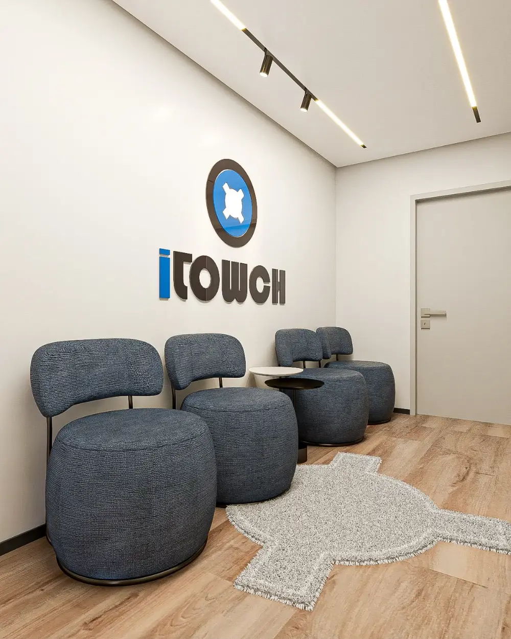 Sala de espera da loja iTowch, com logo da marca na parede e poltronas azuis